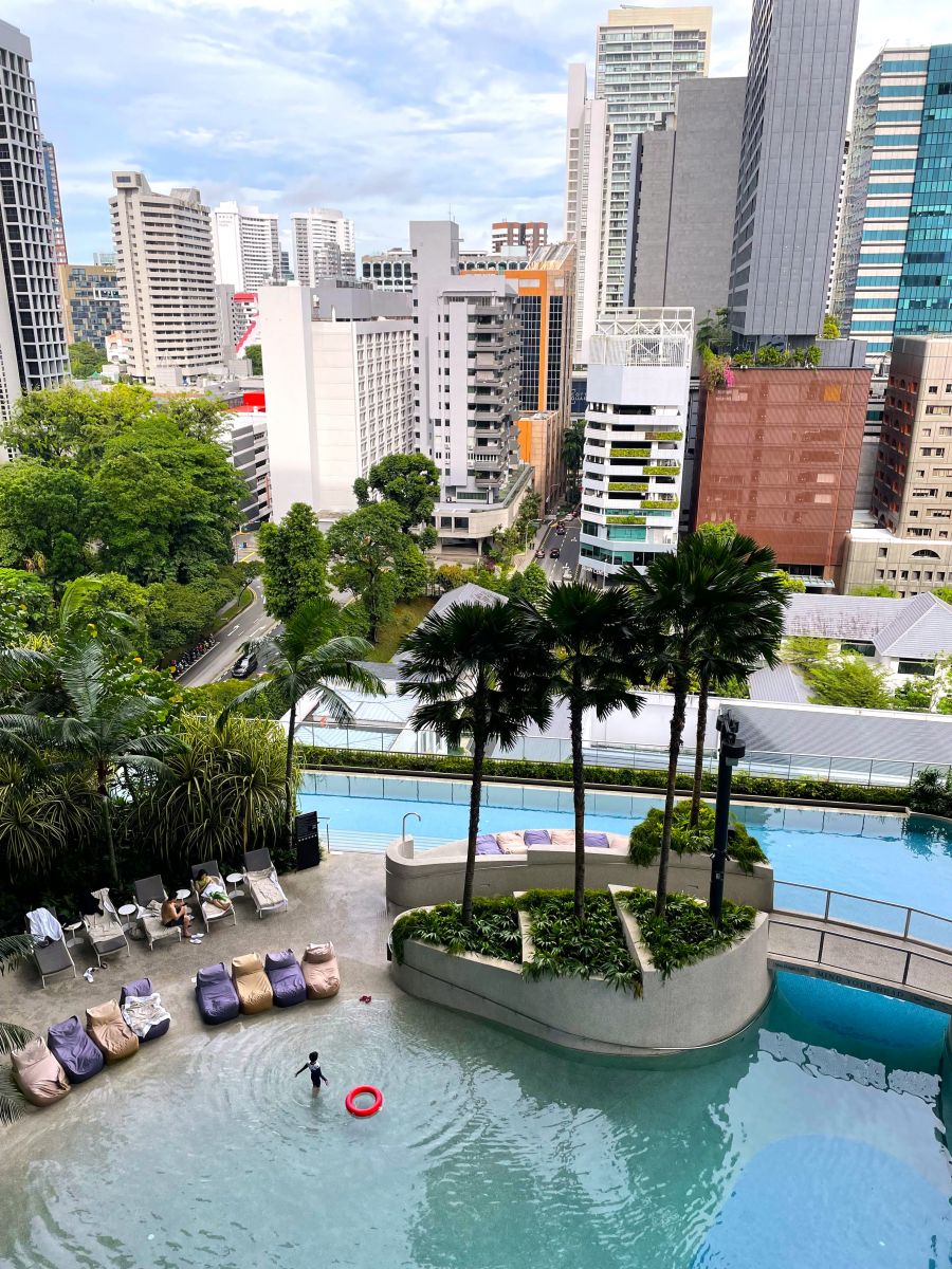 <who>Photo credits: Steve MacNaull/NowMedia Group, above, and Darren Son, below</who>The lagoon pool, above, at Pan Pacific Orchard Hotel. The hotel, below, looks like its constructed of giant Jenga blocks.